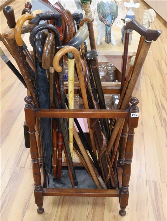 A Victorian mahogany stick stand containing a collection of walking sticks